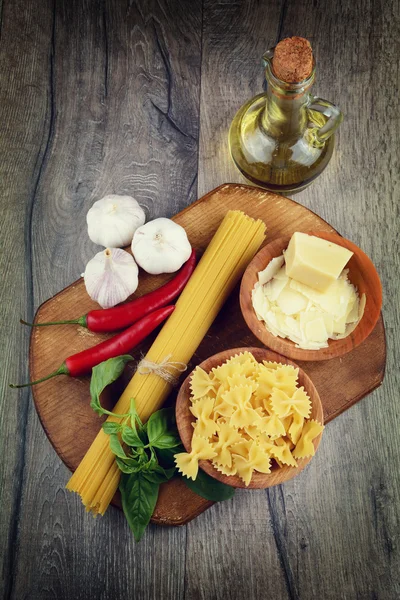 Esparguete cru e macarrão farfalle na mesa — Fotografia de Stock