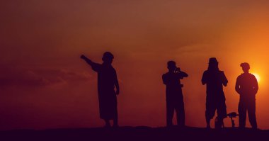 Behind the scenes. The team filmed the movie scene outdoors at sunset. Concept silhouette. Videographer's work. Filming the MV.