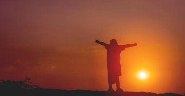 silhouette concept of man standing on mountain and sun light On a hot day causing the sky to darken