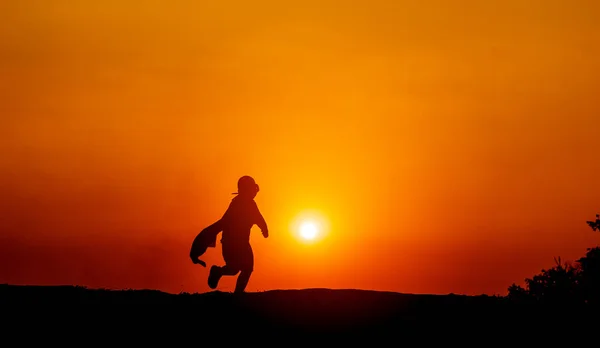 スーパーヒーローのシルエットは決意と決意で前に飛び出します 背景に太陽とジョギングシルエットのコンセプトと夜のランニング — ストック写真