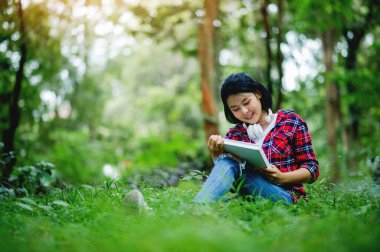 Ormanda kitap okumak ve eğlenmek, sessiz ve rahatlatıcı atmosferi düşünmek ve düşünmek..