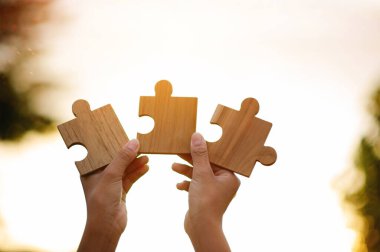 Tahta yapboz ve parlak güneş ışığı güçlü bir işbirliği ve takım çalışmasını temsil ediyor..