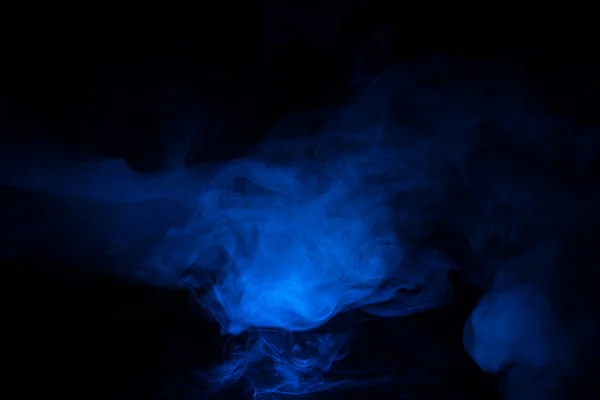 Блакитний дим на темному тлі — стокове фото
