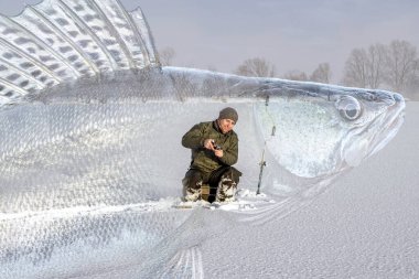 Winter zander fishing. Fisherman catching walleye fish on snowy ice at frozen lake on blurred pikeperch background. Soft focus clipart