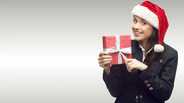 Geschäftsfrau mit Weihnachtsmann-Hut hält Geschenk in der Hand — Stockfoto