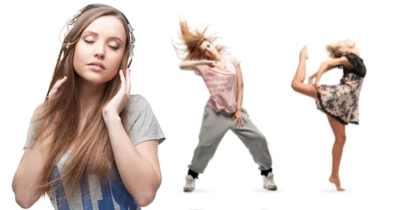 Mujer joven escuchando música y dos bailarinas en el fondo — Foto de Stock