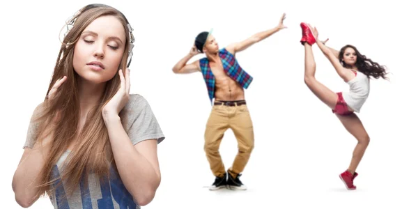 Ung kvinna lyssnar musik och två dansare på bakgrund — Stockfoto