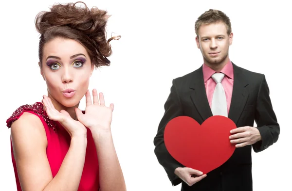 Young surprised woman and handsome man holding red heart on whit — Stock Photo, Image