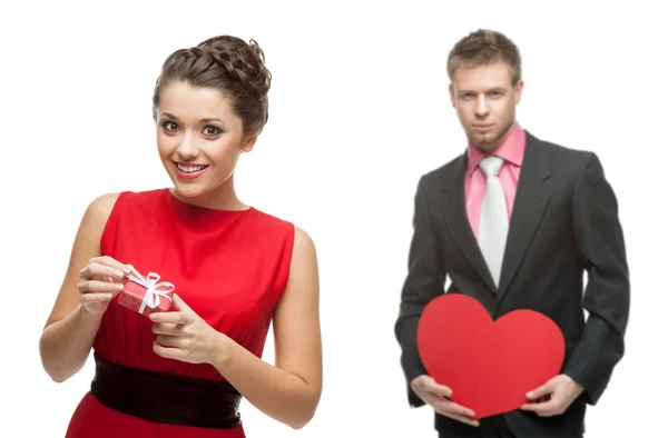 Young smiling woman and handsome man holding red heart on white — Stock Photo, Image