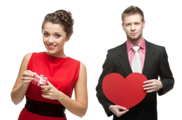 Joven mujer sonriente y hombre guapo sosteniendo el corazón rojo en blanco — Foto de Stock