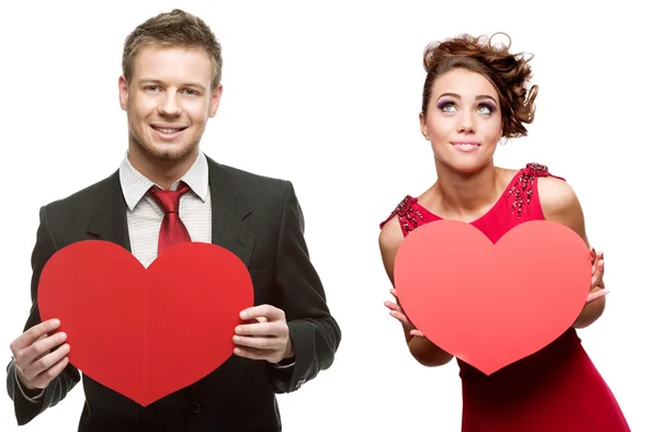 Fiatal jóképű férfi, gazdaság piros szív és vidám nő fehér — Stock Fotó