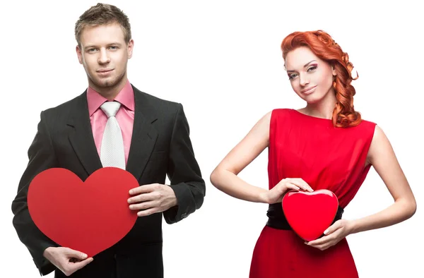 Mladý pohledný muž drží červené srdce a veselá žena na bílém pozadí — Stock fotografie