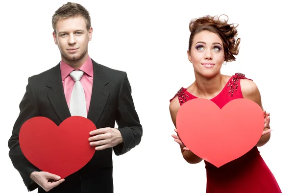 Joven hombre guapo sosteniendo el corazón rojo y la mujer alegre en blanco —  Fotos de Stock