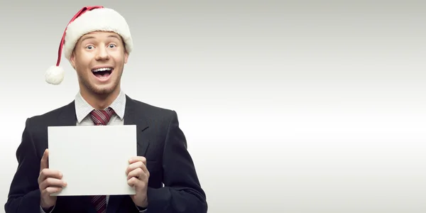 Businessman in santa hat holding sign — Stock Photo, Image