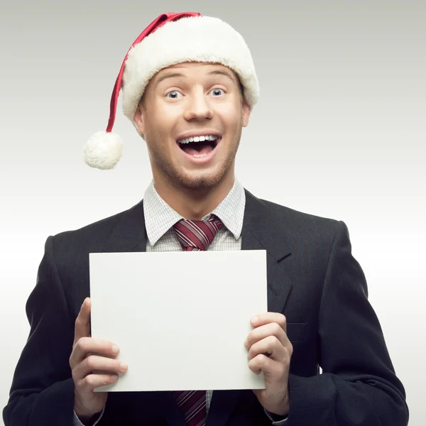 Uomo d'affari in cappello Babbo Natale con cartello — Foto Stock