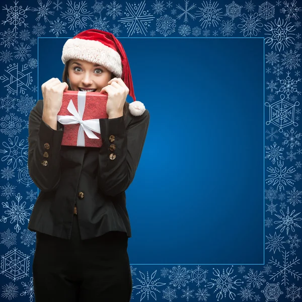 Geschäftsfrau mit Weihnachtsmann-Hut hält Geschenk in der Hand — Stockfoto