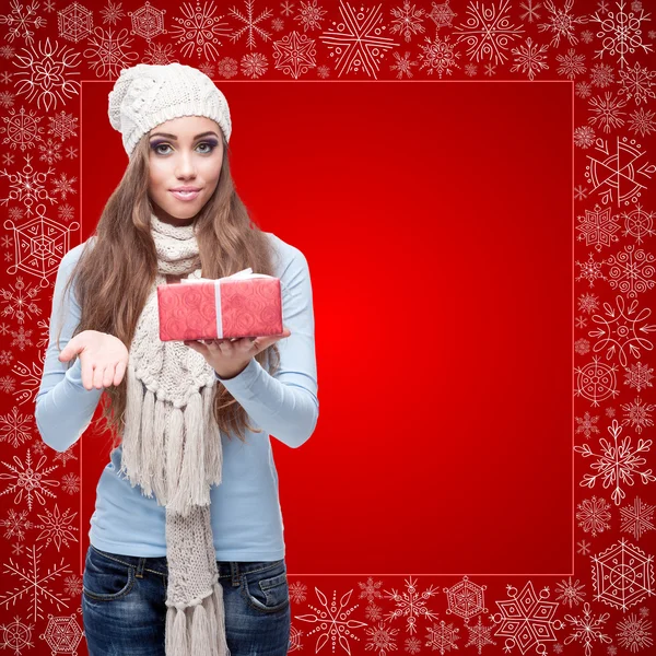 Feliz joven mujer sosteniendo regalo sobre fondo de invierno — Foto de Stock