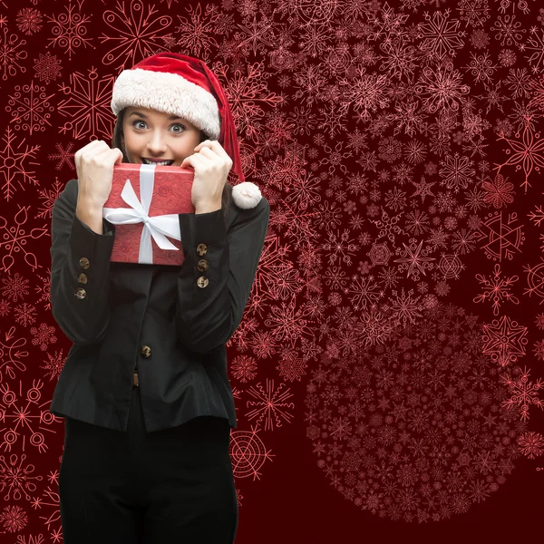 Geschäftsfrau mit Weihnachtsmann-Hut hält Geschenk in der Hand — Stockfoto