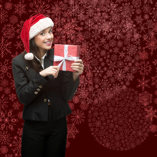 Donna d'affari in Santa hat in possesso di regalo — Foto Stock