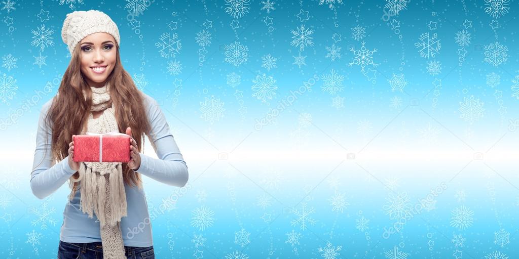 happy young woman holding gift over winter background