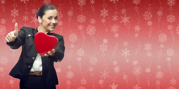 Cheerful business woman holding heart over winter background — Stock Photo, Image