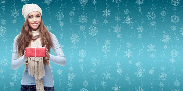 Gelukkig jonge vrouw houdt geschenk over winter achtergrond — Stockfoto