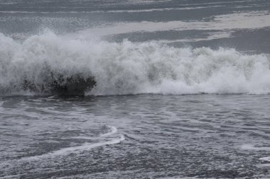 Kumlu sahile vuran dalgaların görüntüsü.