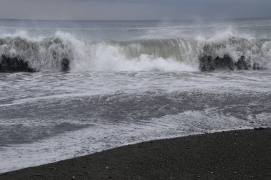 Kumlu sahile vuran dalgaların görüntüsü.
