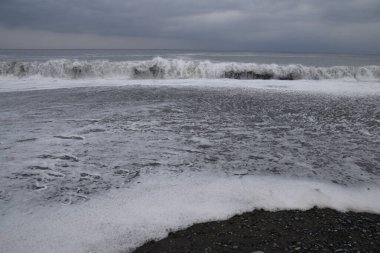 Kumlu sahile vuran dalgaların görüntüsü.