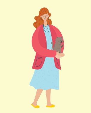 Güzel kız kucağında sevimli bir kedi tutuyor..