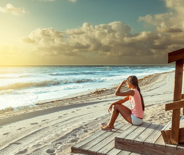 Женщина сидит на пляже — стоковое фото