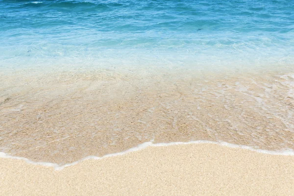 Mořská vlna přes písečnou pláž. — Stock fotografie