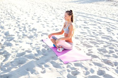 Sahilde yoga yapan bir kız.