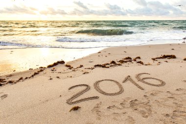 Yıl 2016 günbatımı kum üzerine yazılmış