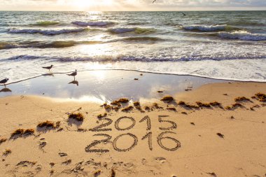 2015 and 2016 signs on a beach sand clipart