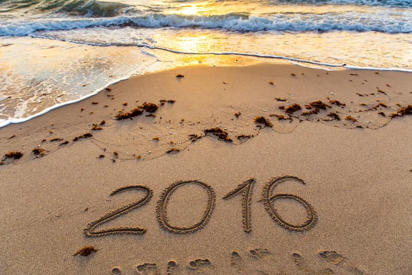 Ano 2016 escrito na areia ao pôr do sol — Fotografia de Stock