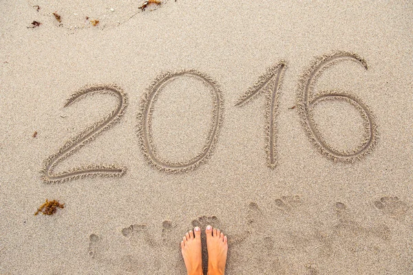 2016 sign on the sand and womans foot — Stock Photo, Image