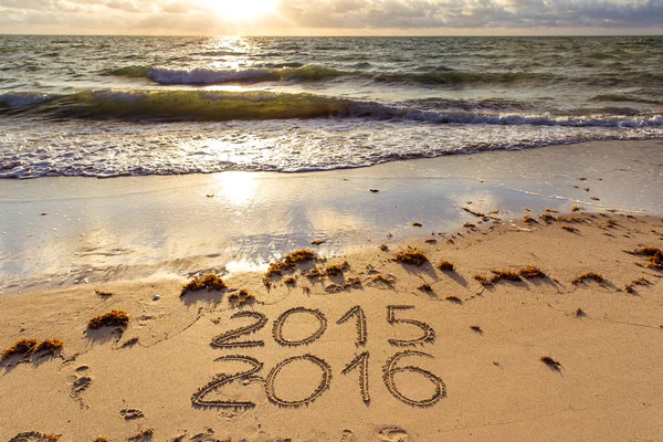 Carteles de 2015 y 2016 en una arena de playa — Foto de Stock