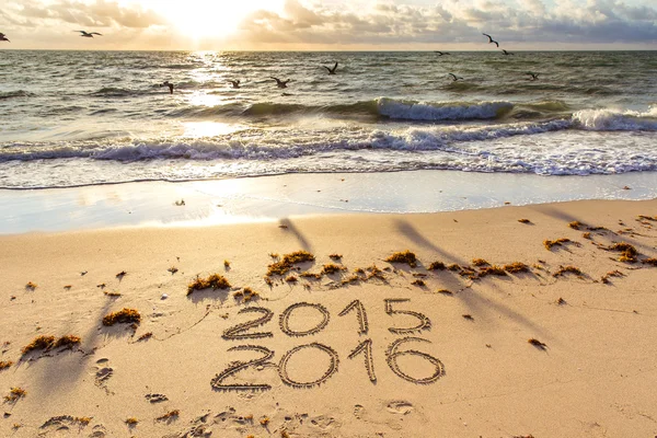 Carteles de 2015 y 2016 en una arena de playa — Foto de Stock