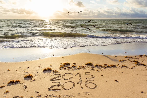 2015 e 2016 sinais em uma areia de praia — Fotografia de Stock