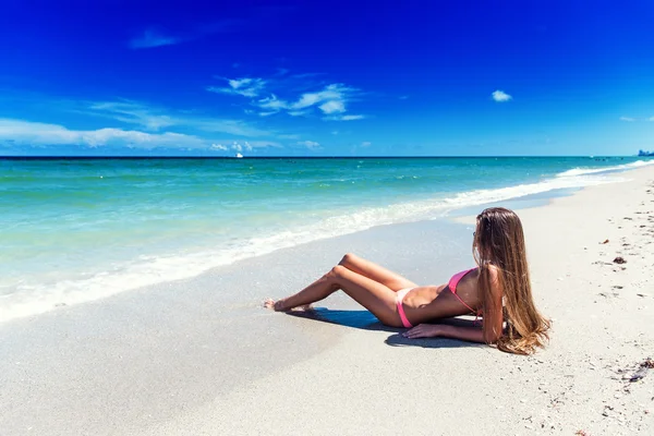 Tjej i bikini poserar på den tropiska stranden — Stockfoto