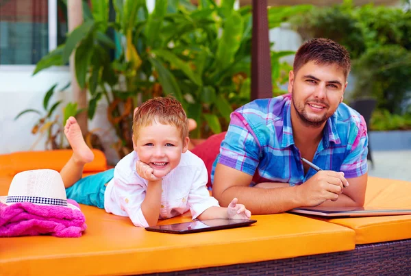 Heureux père et fils occupés avec tablette numérique en vacances — Photo