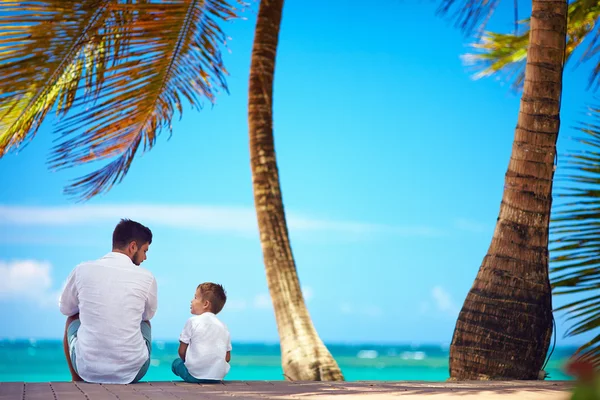 Щасливий батько і син сидять разом біля моря — стокове фото