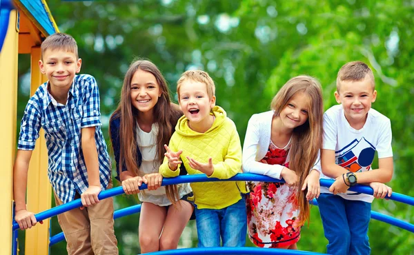 Gelukkig opgewonden kinderen hebben plezier samen op de speelplaats — Stockfoto
