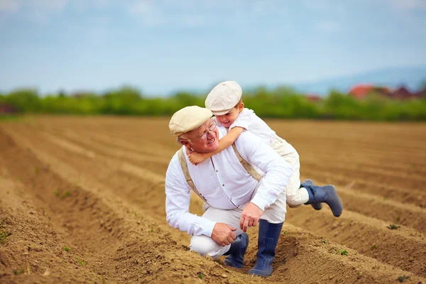 Laughing grandfather and grandson having fun on spring field, countryside — Stock Photo, Image