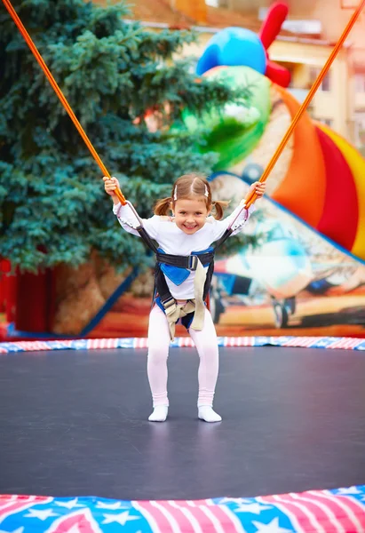 Feliz menina pulando na corda trampolim — Fotografia de Stock