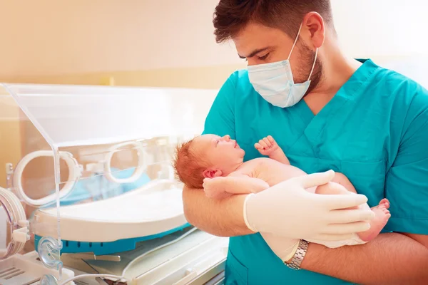 Homem adulto jovem segurando um bebê recém-nascido no hospital — Fotografia de Stock