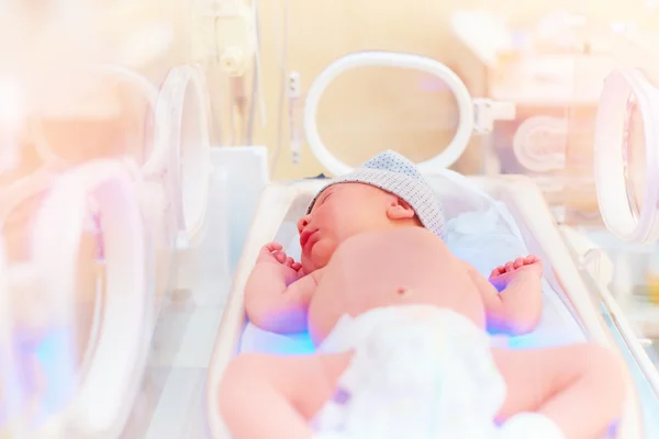 Новорожденный ребенок получает светотерапию в детском инкубаторе — стоковое фото