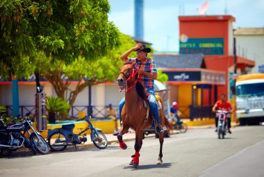 Dominik Cumhuriyeti - 30 Ağustos 2015: şehir yolda bir binicilik genç kovboy