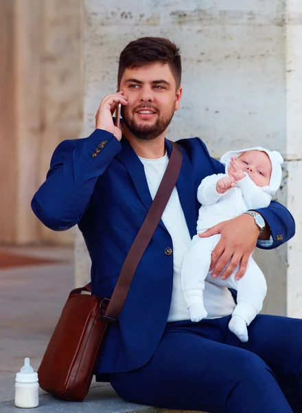 happy young father busy with work with his newborn son